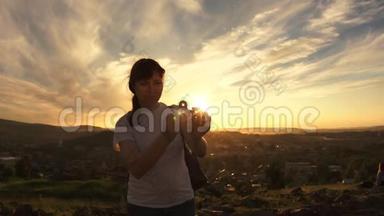 一个年轻的女人在一个夏天的晚上站在日落时扭动旋转器。